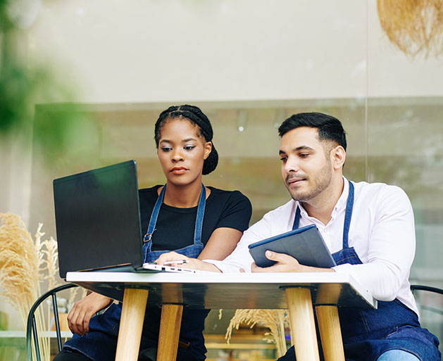 Restaurant employees looking over sales reporting tools from GeminiPay