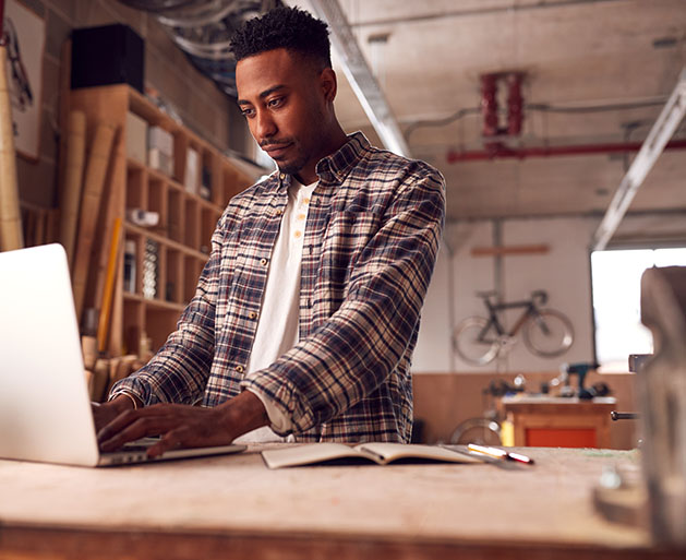 A male business owner looking over his business performance with GeminiPay's merchant services on a laptop