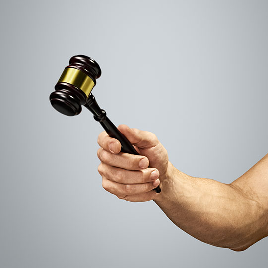 A hand holding a gavel